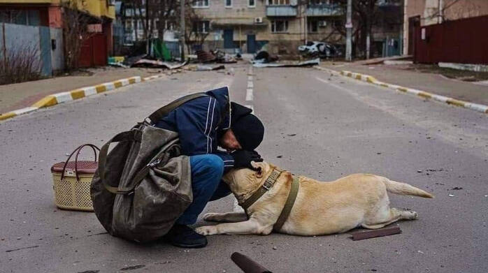 La periodista Hanna Liubakova muestra en esta imagen a Andriy Kulik tratando de consolar a su perro, paralizado en medio de la calle por el miedo, en la ciudad de Irpin (Ucrania).
