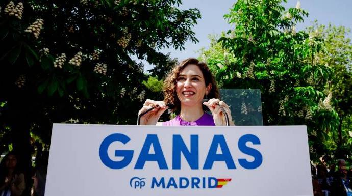 Ayuso junto al lema del congreso del PP de Madrid que arranca este viernes: "Ganas".