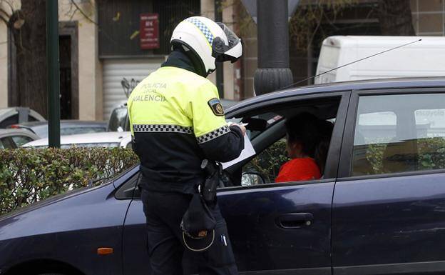 Imagen de archivo de un Policía Local multando a un vehículo. 