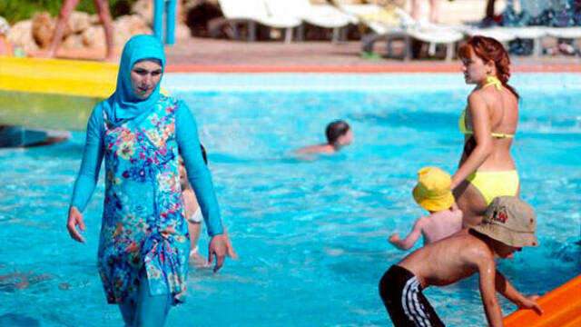 Mujer con burkini en una piscina pública