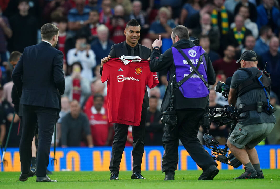 Casemiro posa con la camiseta del Manchester United sobre el césped de Old Trafford.