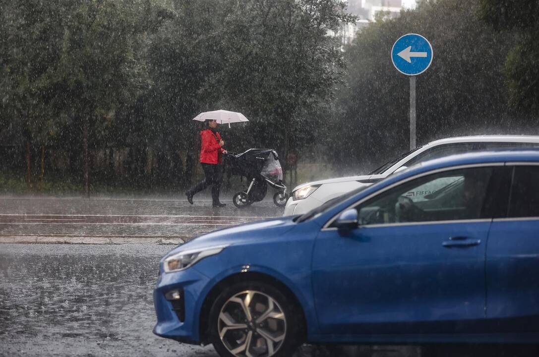 Una mujer lleva un carrito de bebé mientras se protege de la lluvia con un paraguas, - Rober Solsona - Europa Press
