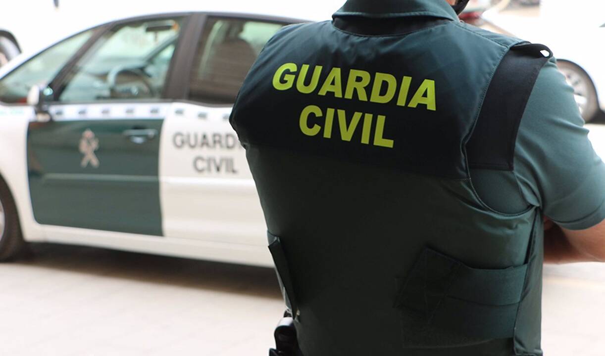Un agente de la Guardia Civil, de espaldas, junto a un vehículo oficial - GUARDIA CIVIL