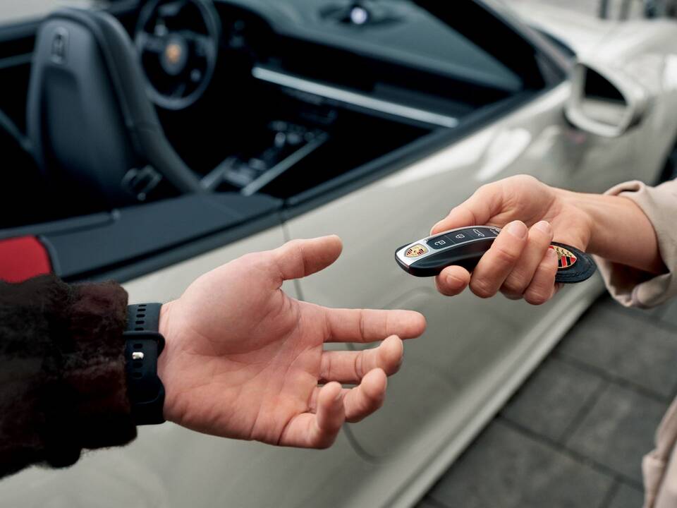Entrega de las llaves a un cliente tras alquilar un Porsche