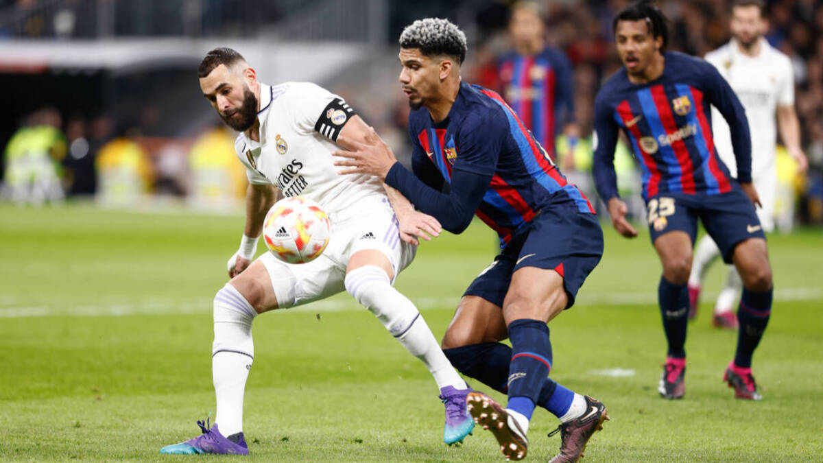 Karim Benzema protege un balón ante Araújo. 