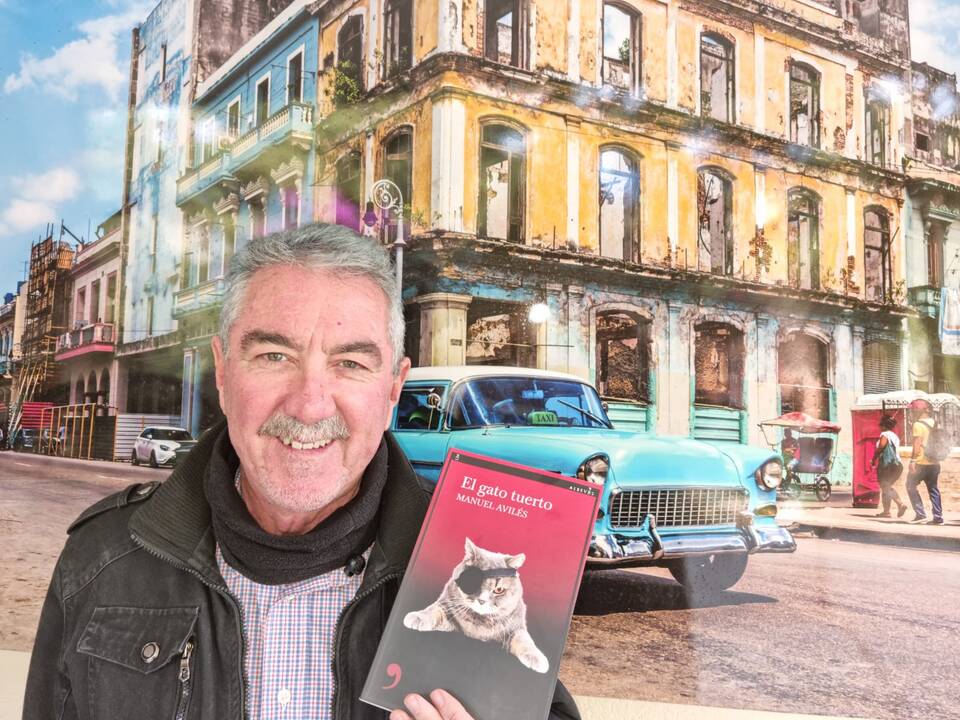 Manuel Avilés con un ejemplar de su libro El gato tuerto.