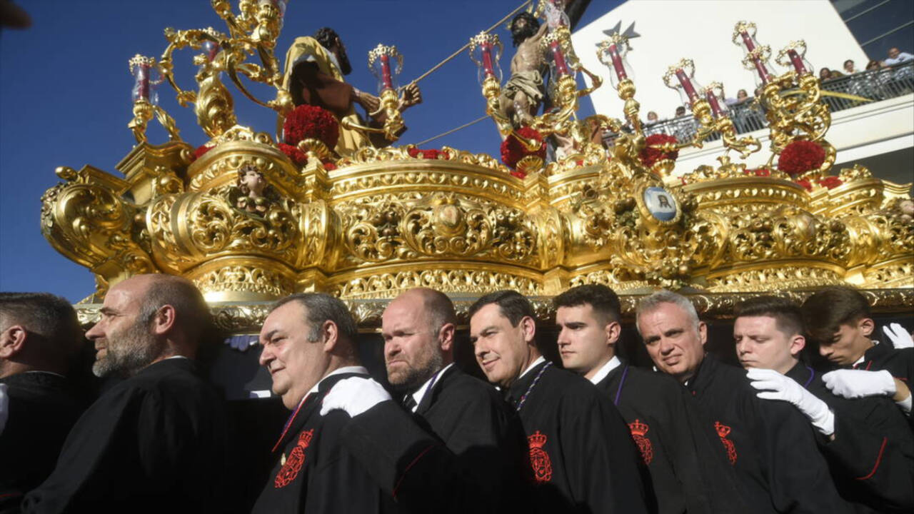 El presidente de la Junta Juanma Moreno como hombre de trono portando el Cristo de la Exaltación, este Miércoles Santo en Málaga.