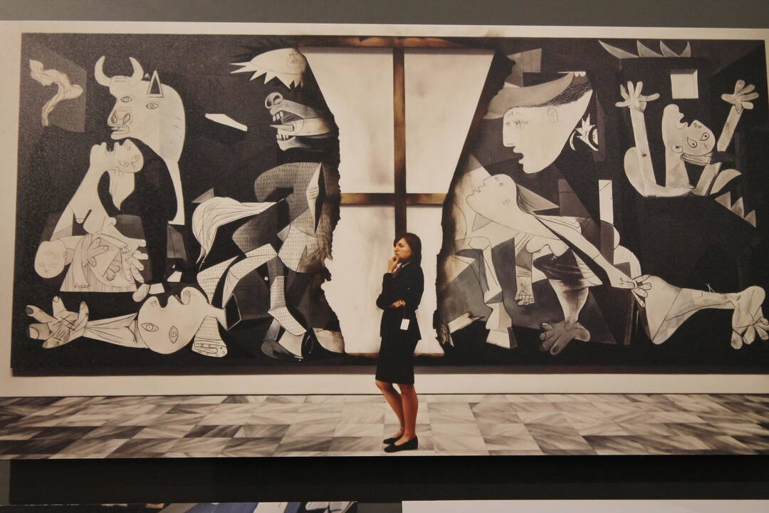 Una mujer enfrente de una de las piezas que conforman la exposición ‘Picasso. El viaje del Guernica’, en los Jardines del Torreón