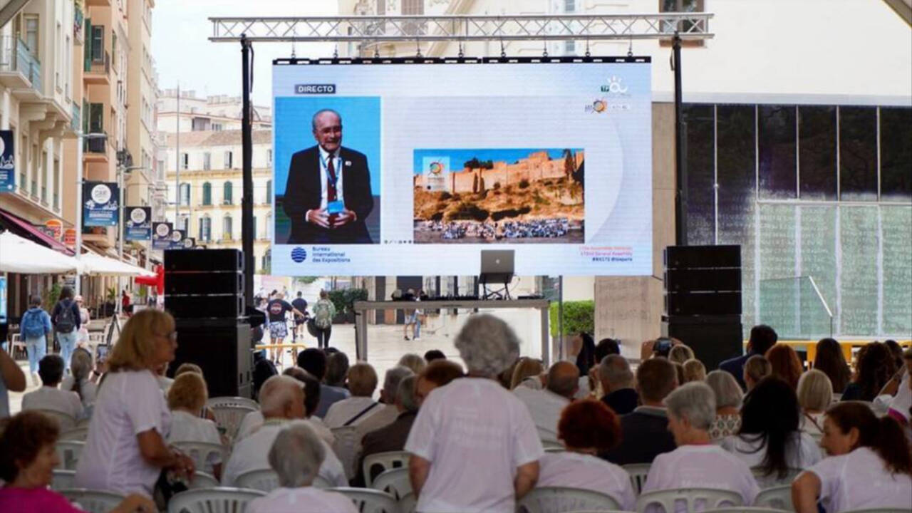 Vecinos de Málaga siguiendo la elección  en París de la sede de la Expo 27.