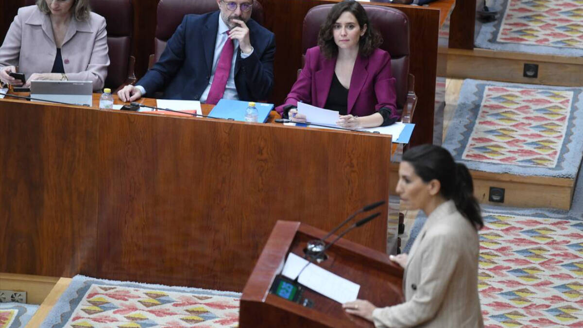 La presidenta de la Comunidad de Madrid, Isabel Díaz Ayuso, escucha a la portavoz de Vox en la Asamblea, Rocío Monasterio.