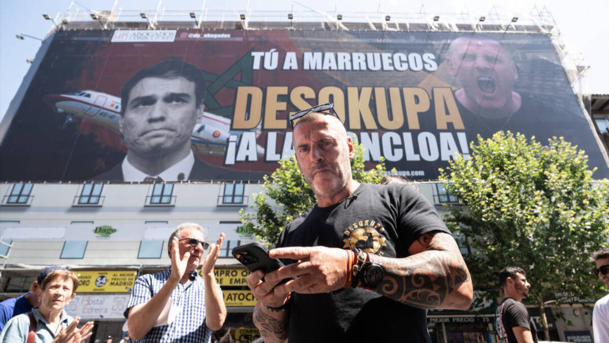 Dani Esteve, líder de Desokupa, junto al cartel en Madrid contra Pedro Sánchez, Gabriel Rufián y más figuras de la izquierda española.