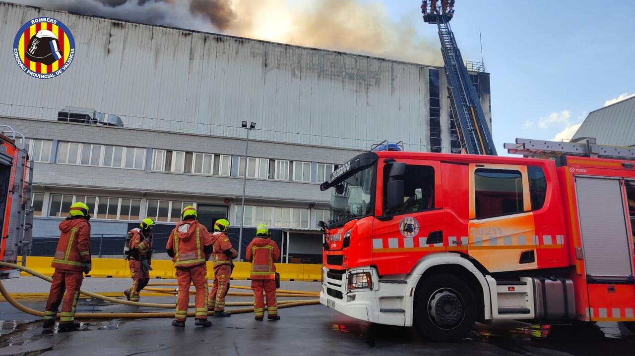 Bomberos trabajan en un incendio que afecta a una nave industrial del polígono de Riba-roja de Turia