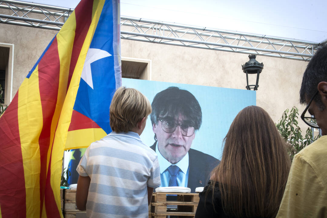 Un niño observa la intervención telemática de Puigdemont en el mitin central del partido JxCAT, a 16 de julio de 2023, en Amer, Girona.