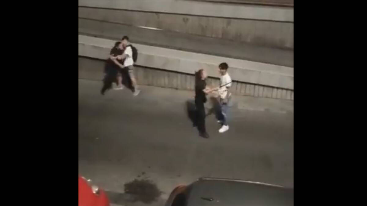 Imagen de un momento de la pelea en Usera, con uno de los agentes siendo sujetado por uno de los jóvenes.