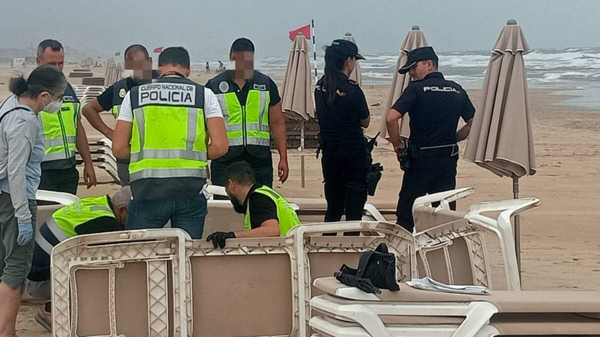 Agentes de la Policía analizan los restos humanos en la playa de Gandia