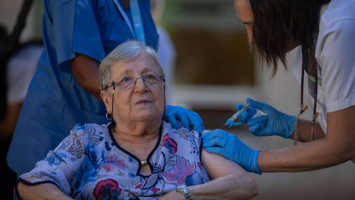 Una mujer se vacuna durante el inicio de la campaña de vacunación en Cataluña.