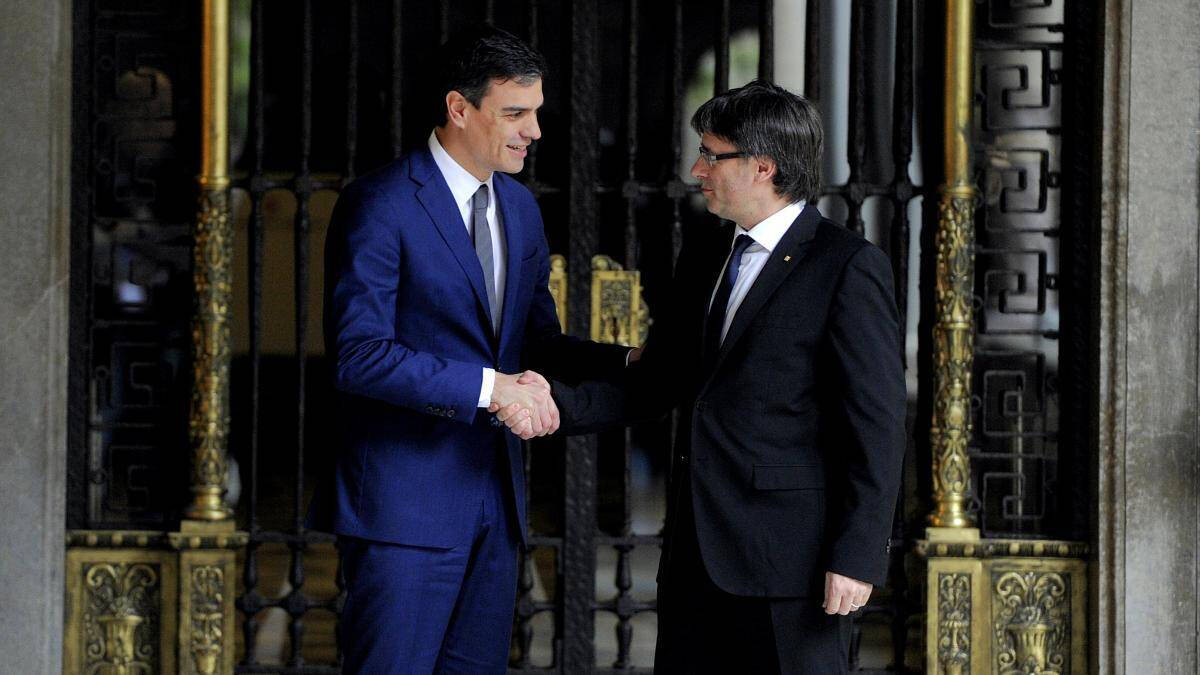 Pedro Sánchez junto a Carles Puigdemont dándose la mano