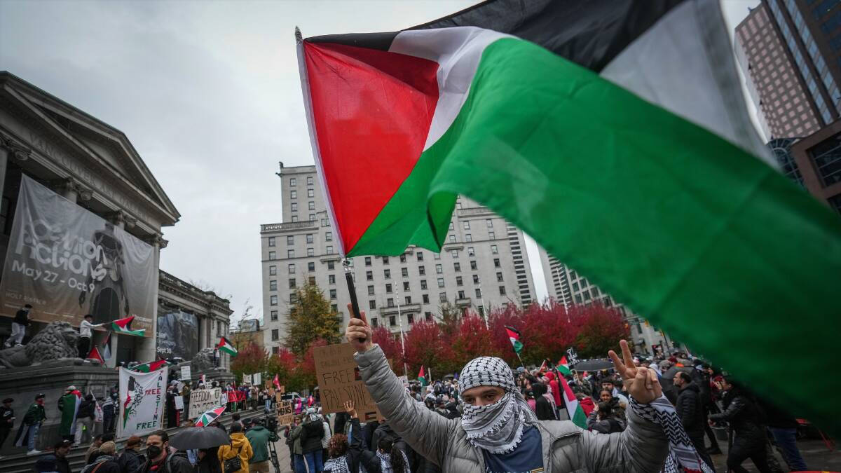 Un manifestante ondea la bandera de Palestina en una protesta en Vancouver, Canadá.