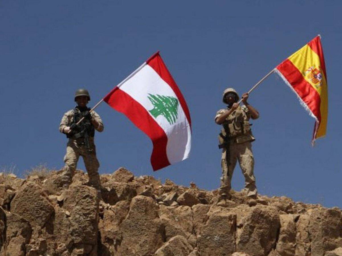 Soldados hondeando las banderas de Líbano y España.