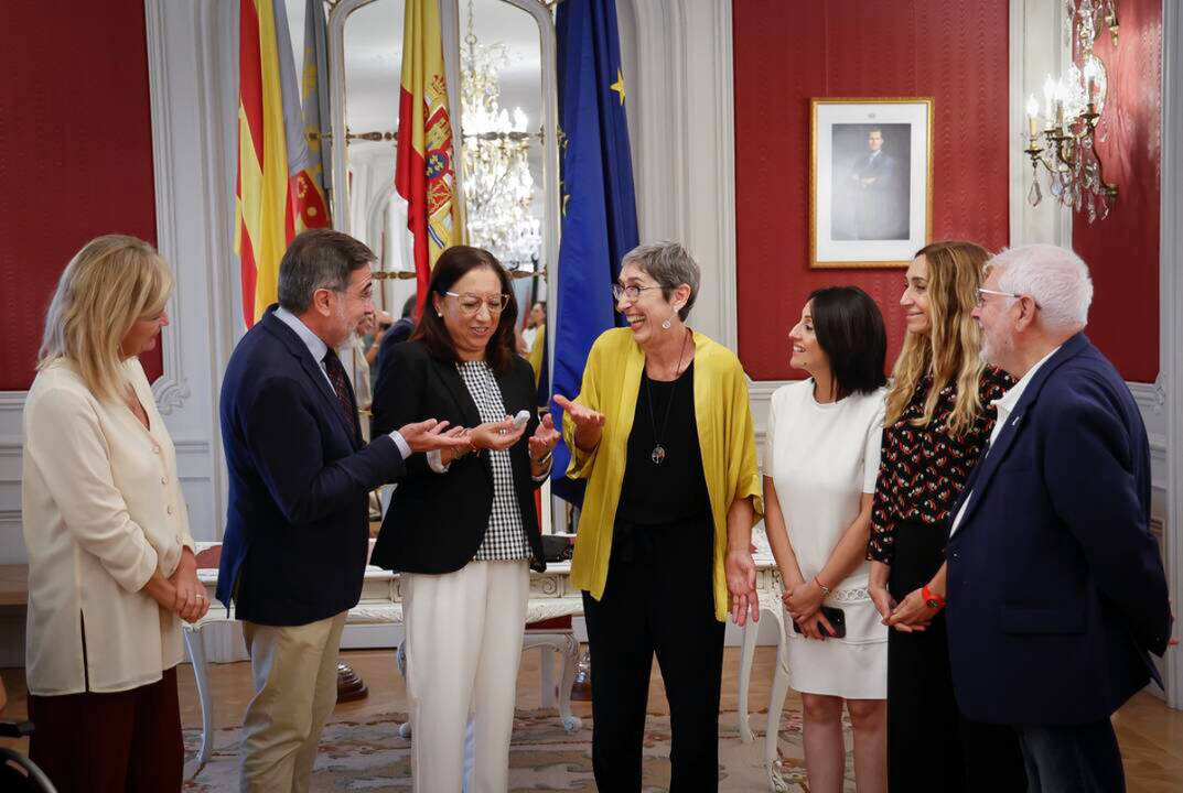 La presidenta de les Corts, Llanos Masó (Vox), conversa con la presidenta en funciones del CVC, con chaqueta amarilla, Dolors Pedrós (Compromís).