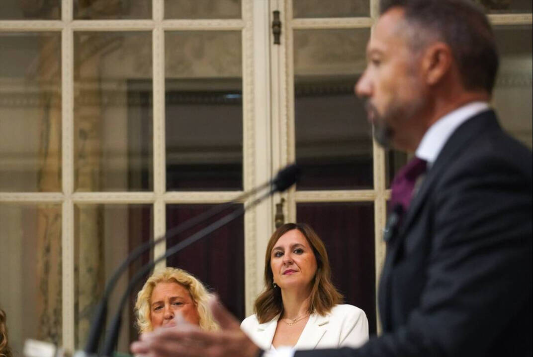 La alcaldesa de València, María José Catalá, observa al portavoz de Vox, Juanma Badenas, en la presentación del pacto de gobierno municipal.
