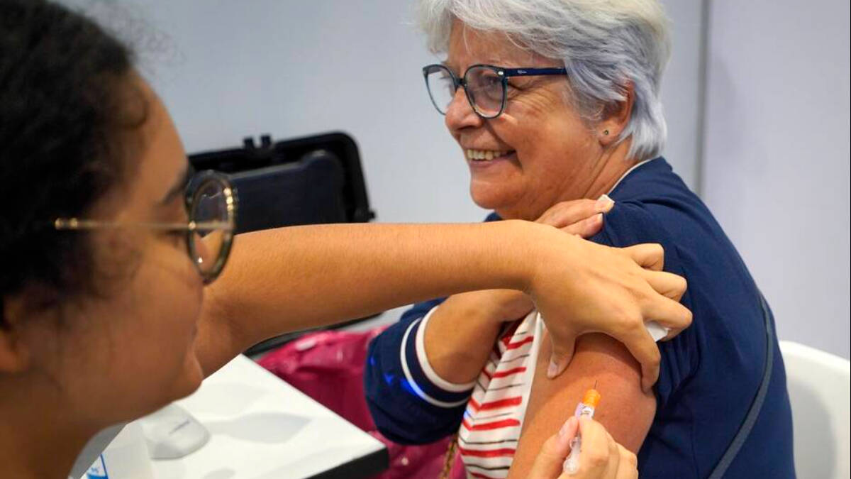 Una mujer se vacuna para la doble inmunización frente al COVID y la gripe.
