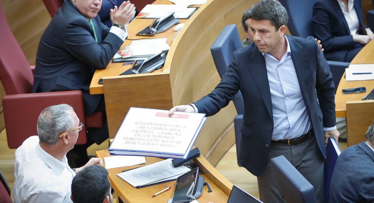 El 'president' Carlos Mazón entrega un documento a Joan Baldoví (Compromís) en la sesión de control en Les Corts