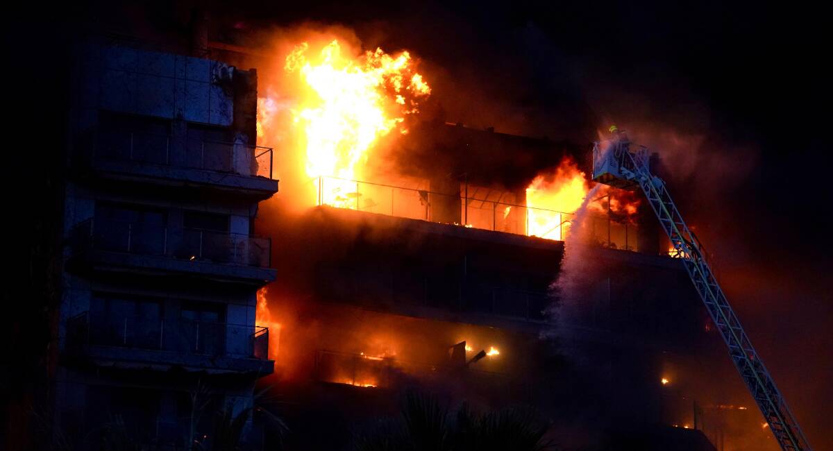 Los bomberos tratan de apagar las llamas de un edificio, en el barrio de Campanar
