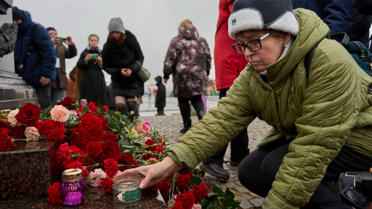 Una mujer rusa deposita flores en memoria de los 133 fallecidos en el atentado de Moscú