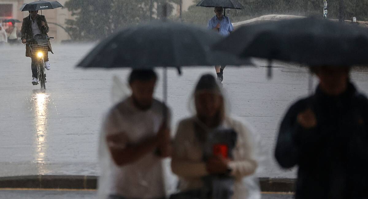 Varias personas con paraguas bajo la lluvia